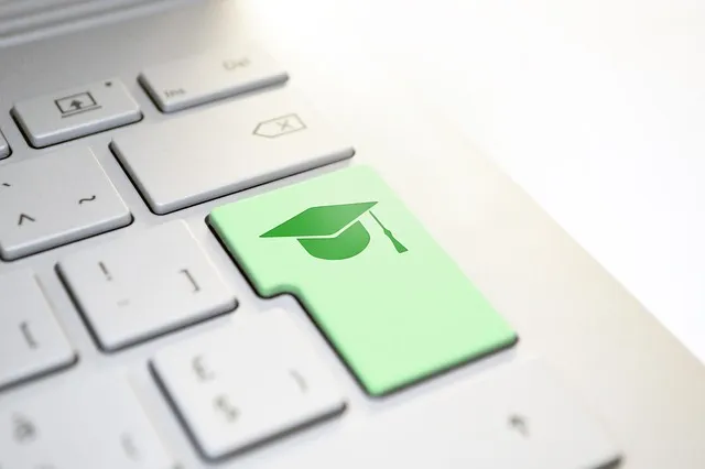 Clavier d'ordinateur avec un zoom sur la touche entrée symbolisée par une toque d'étudiant